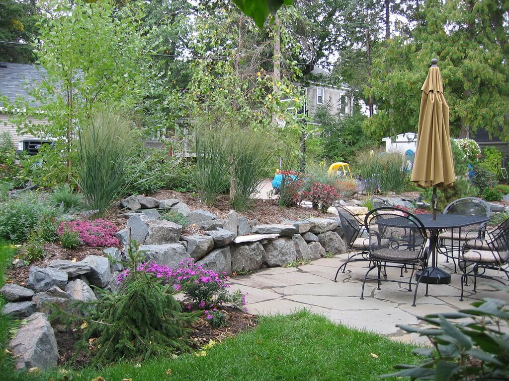 Flagstone patio with outdoor furniture and stone wall